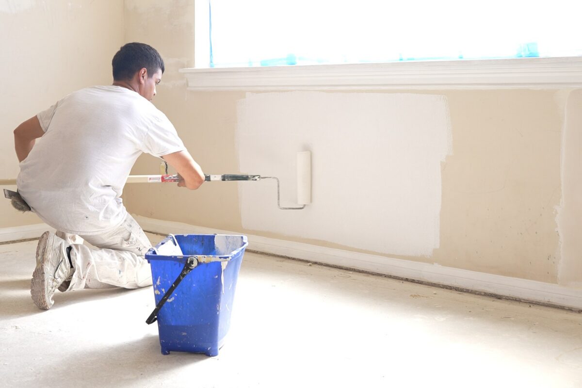 Painter rolling an even coat on a prepared wall